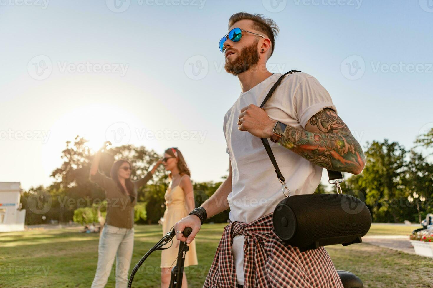 företag av vänner har roligt tillsammans i parkera lyssnande till musik foto