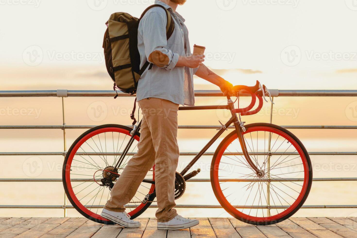 stilig skäggig man reser med cykel i morgon- soluppgång förbi de hav foto