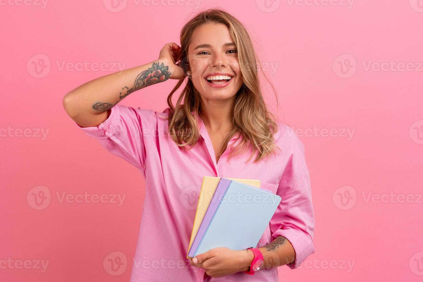 blond Söt kvinna i rosa skjorta leende innehav innehav bärbara datorer foto