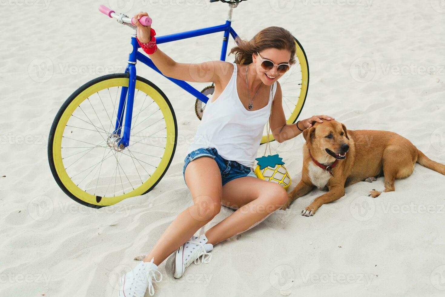 ung skön kvinna Sammanträde på sand på strand, innehav årgång cykel foto