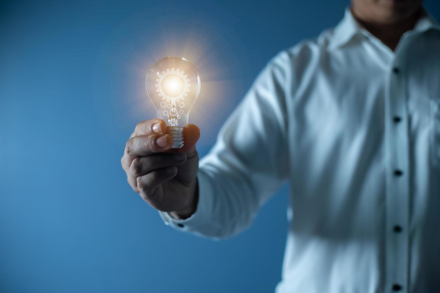 hand affärsman håller glödlampa, innovation och inspiration koncept foto