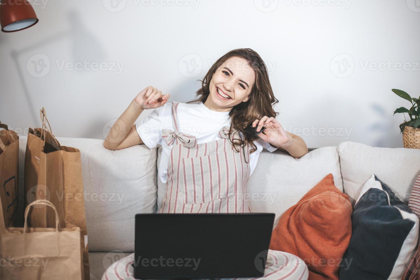 ung tusenårig kvinna som handlar online hemma. foto