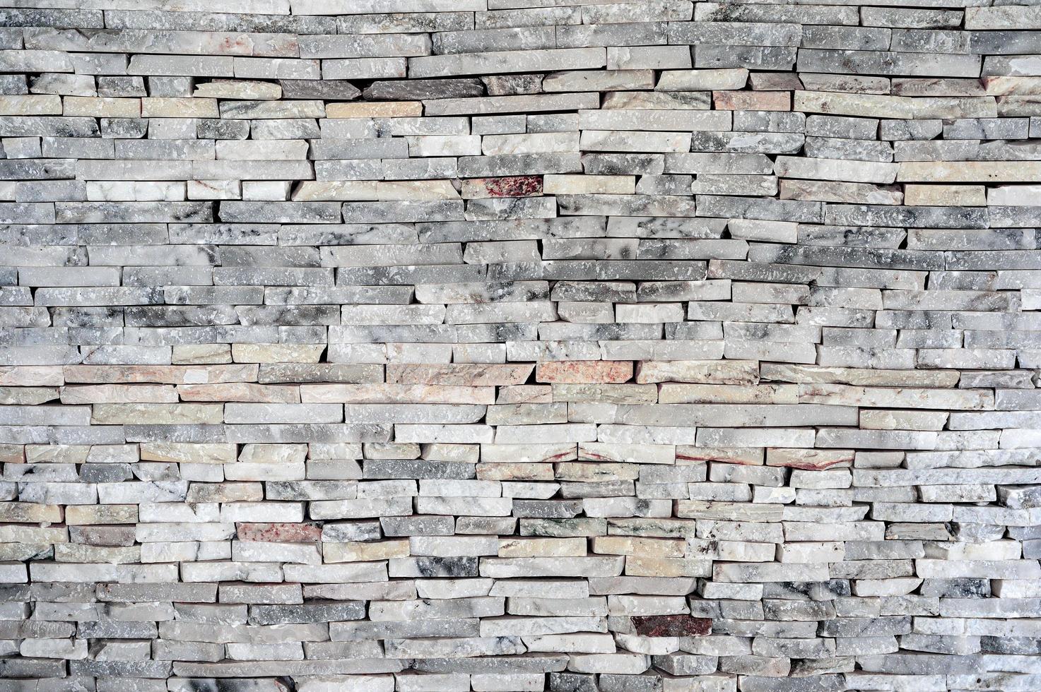 horisontell staplad tegelvägg av granitsten foto