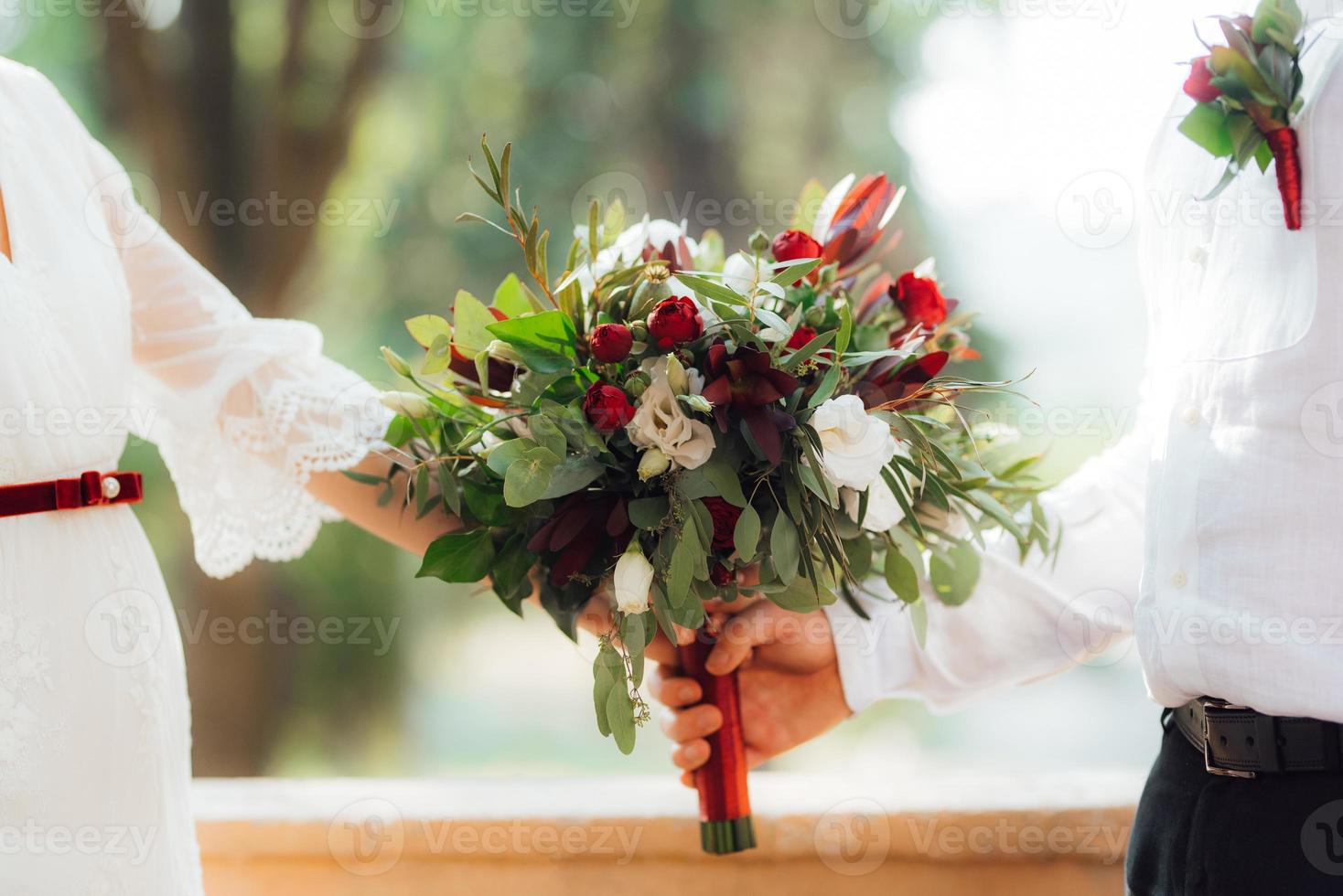 bröllopsbukett med röda blommor och grönska foto