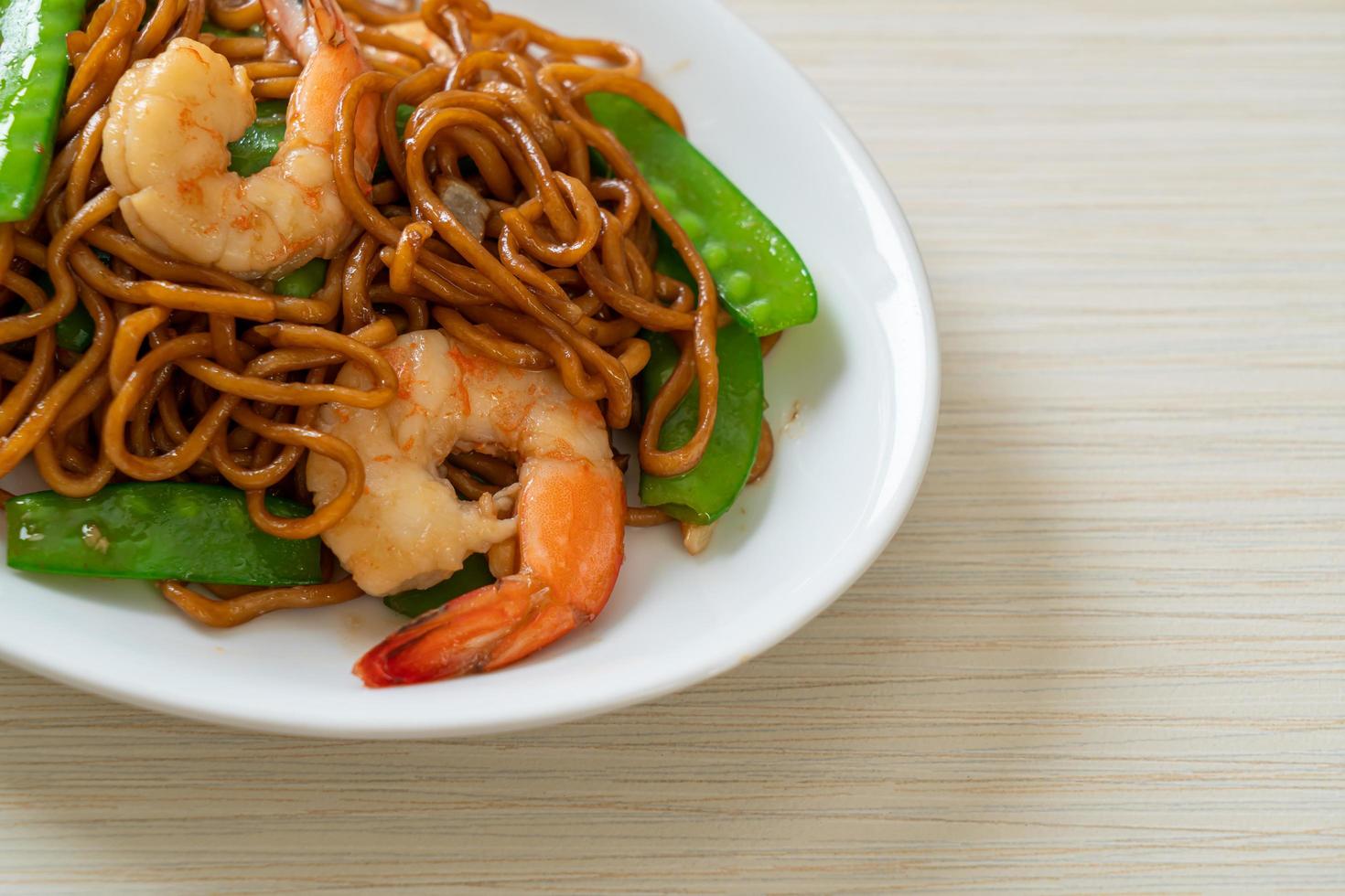 uppstekt yakisoba nudlar med gröna ärtor och räkor - asiatisk matstil foto