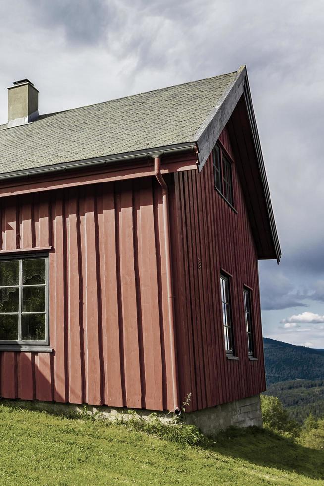 vacker röd trästuga koja på kullen i norge natur. foto