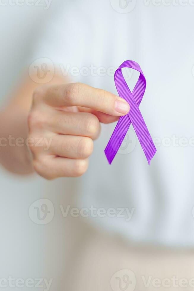 kvinna innehav lila band för våld, pankreas, esofagus, testikulär cancer, alzheimer, epilepsi, lupus, sarkoidos och fibromyalgi. medvetenhet månad och värld cancer dag begrepp foto