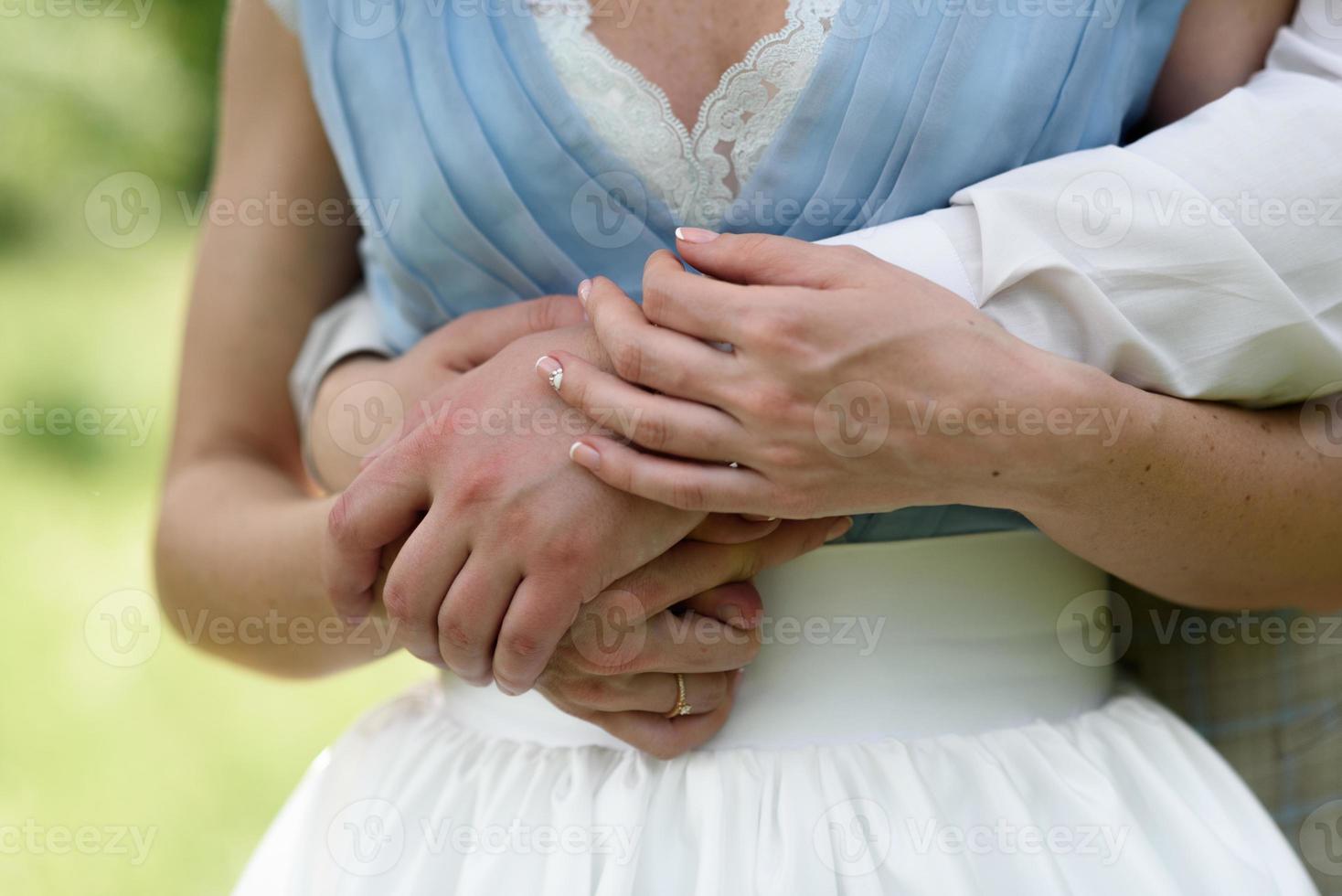 händerna på bruden och brudgummen foto