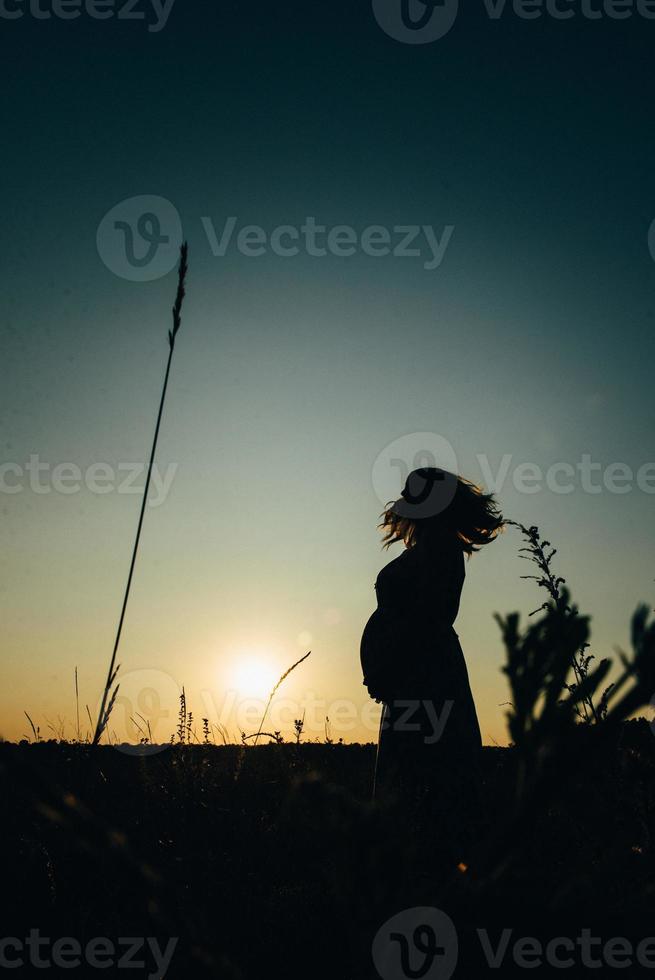 silhuetter av en lycklig ung lycklig familj mot en orange solnedgång foto