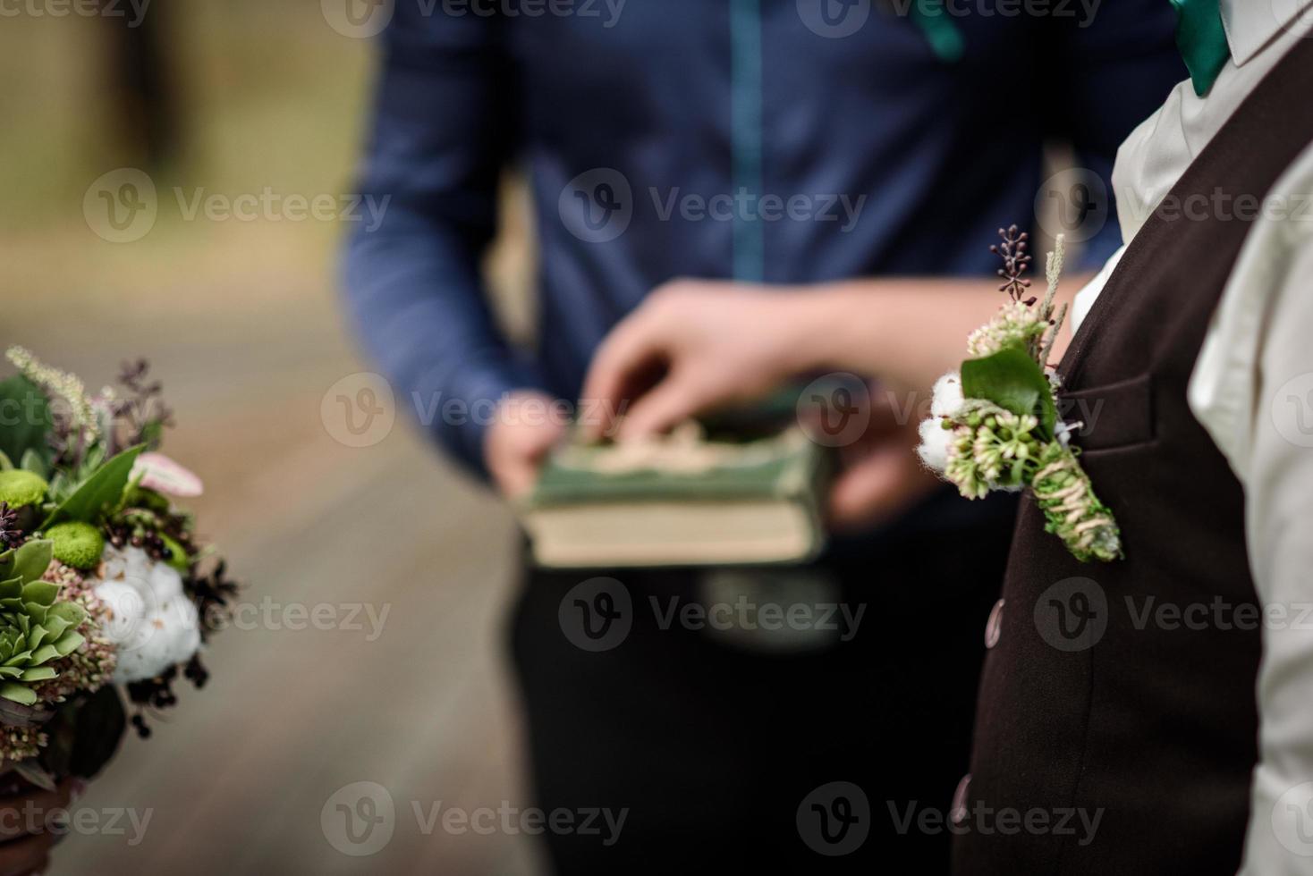 brudgummen sätter vigselring foto