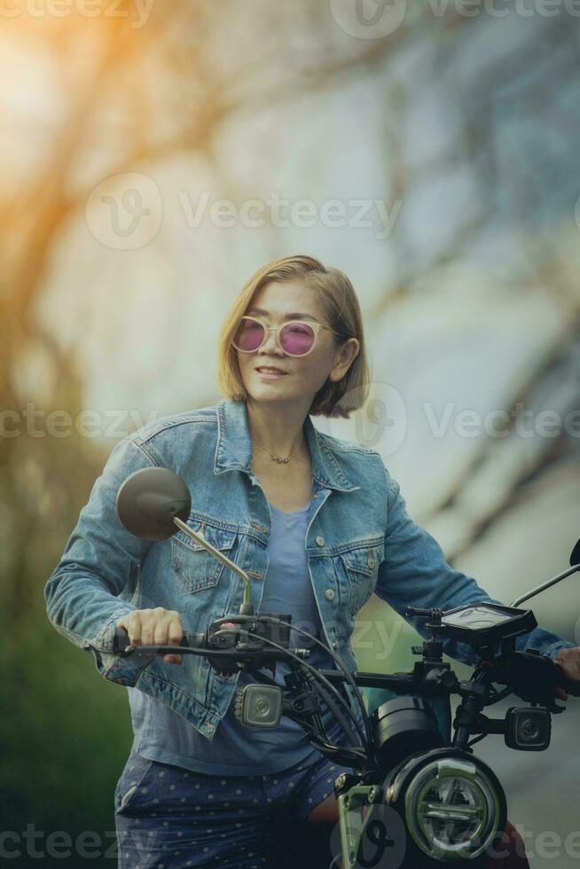 Söt kvinna ridning sport motorcykel på naturlig Spår foto