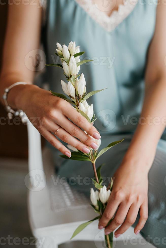 flicka brud i en grå klänning som håller en grön kvist foto