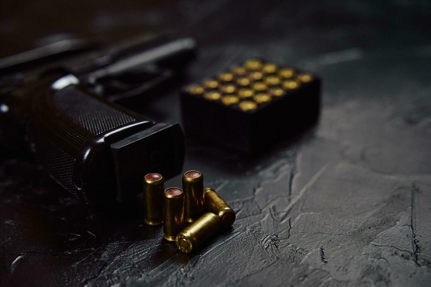 pistol med patroner på svart betongbord. foto