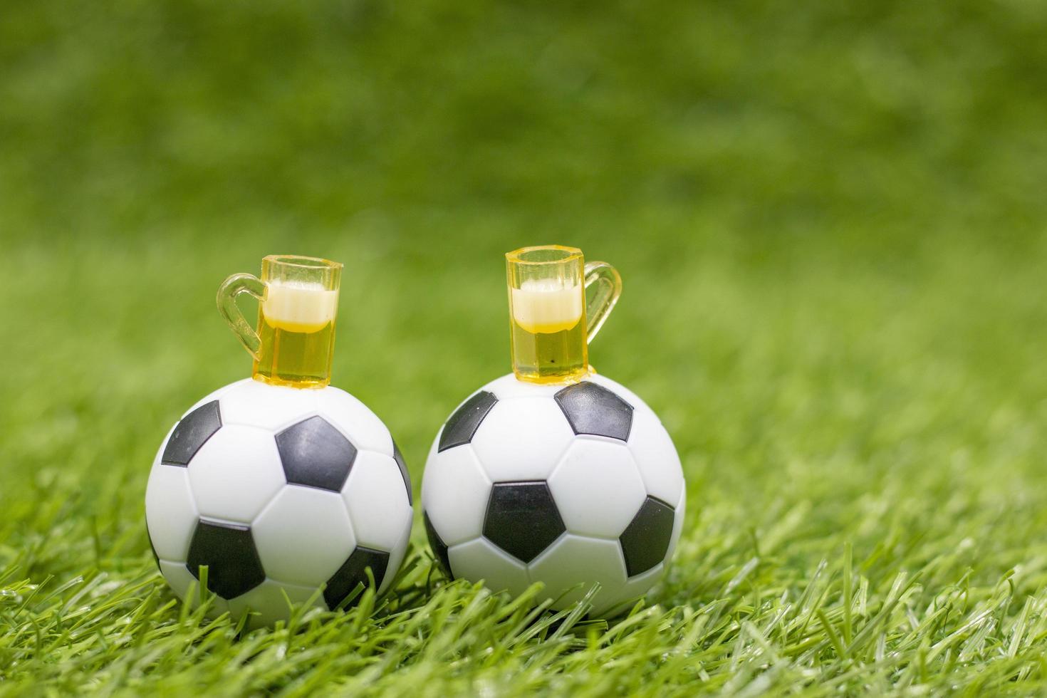 fotboll med glas öl är på grönt gräs foto