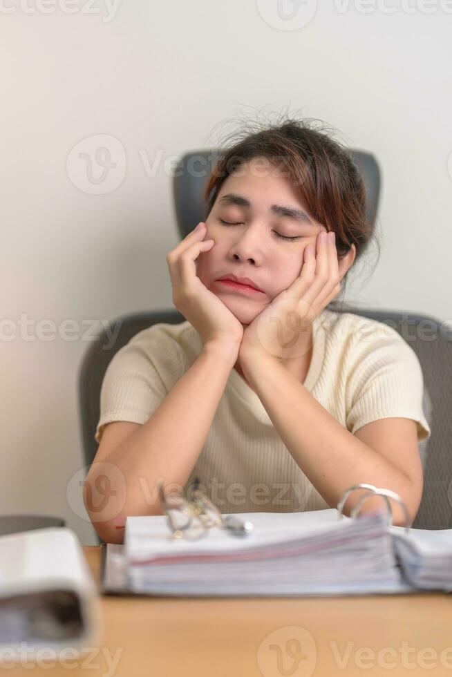 betonade asiatisk kvinna har trött och sömnig medan arbetssätt, kvinna affärskvinna har huvudvärk på kontor, utmattad kvinna med dokument mapp stack på Hem sent natt. överarbetad och över tid foto