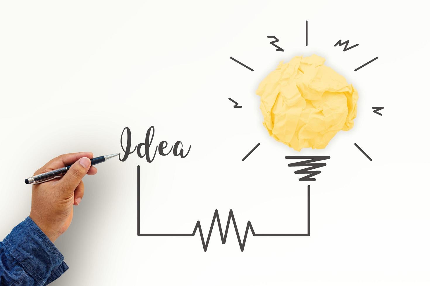 kreativitetsinspiration, idéer och innovationskoncept med glödlampa och pappers skrynklig boll. hand av affärsman som skriver textidé med pennan. foto