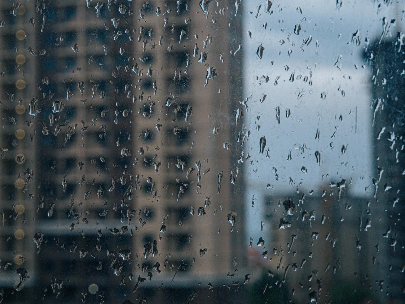 regndroppar på fönster. våta fönster stadsljus regn droppar foto