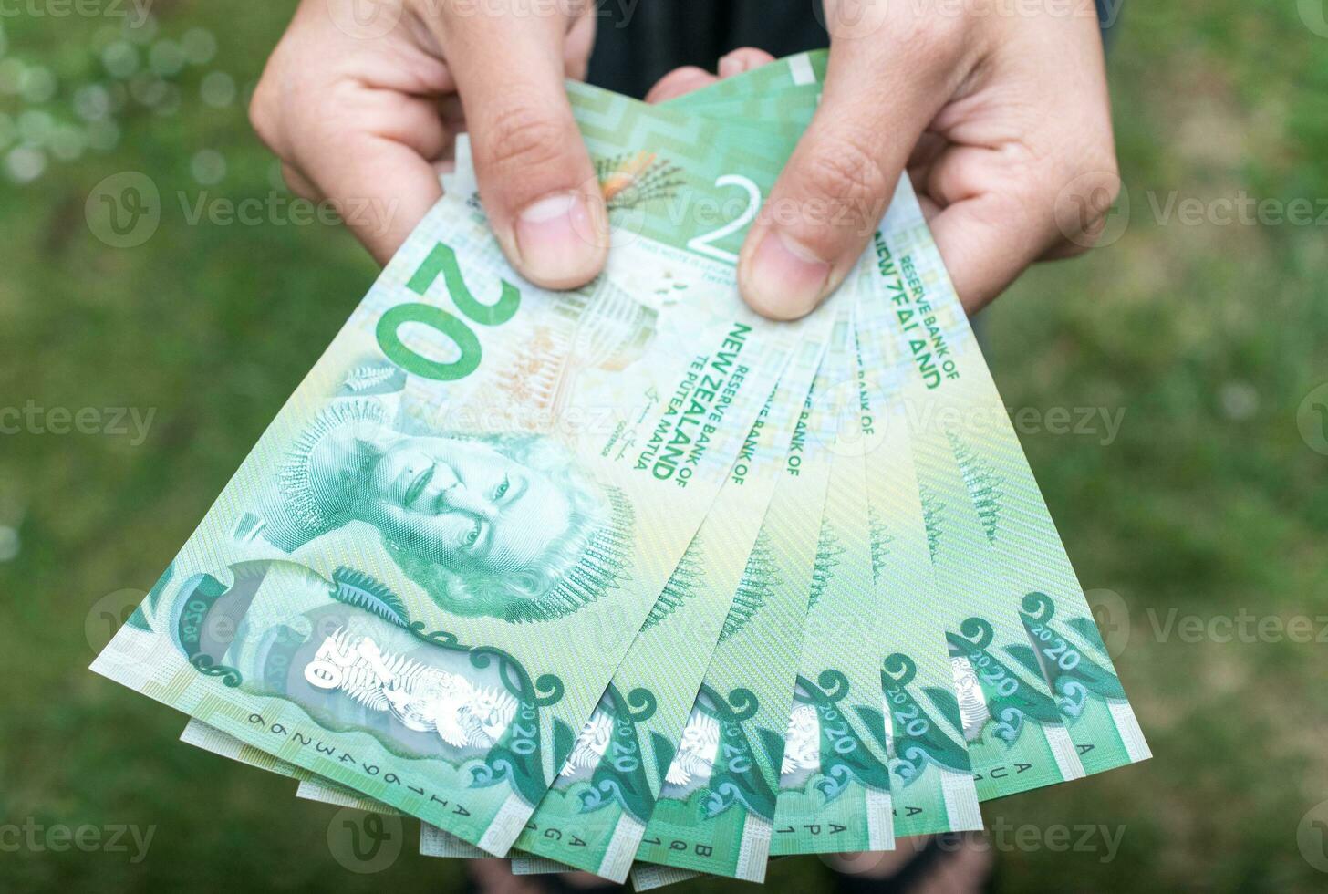 beskurna skott se av någon som visar de pengar ny zealand 20 dollar. foto