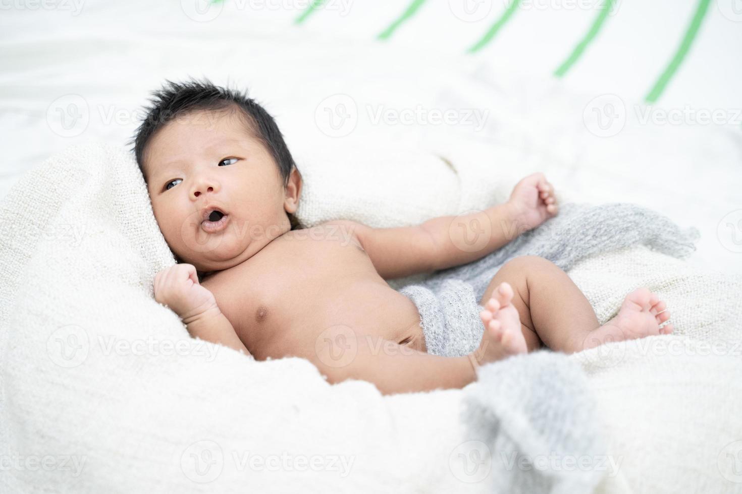 nyfött spädbarn behandla som ett barn pojken som ligger på en vit filt foto