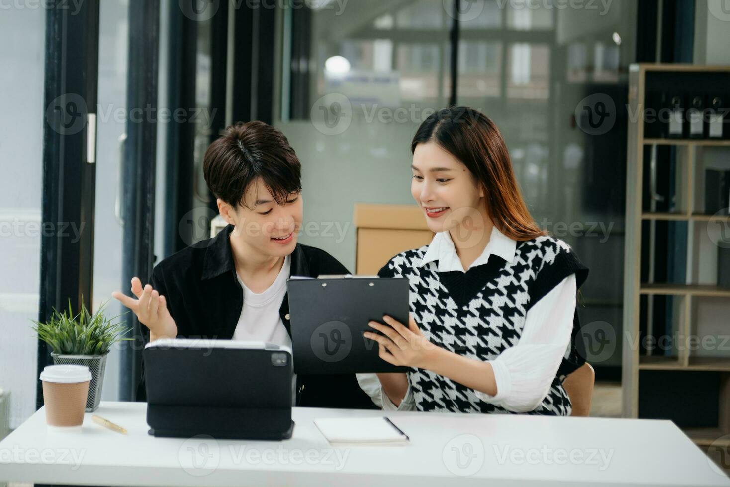 två asiatisk affärskvinna och man diskutera investering projekt arbetssätt och planera strategi med läsplatta bärbar dator dator i kontor. foto