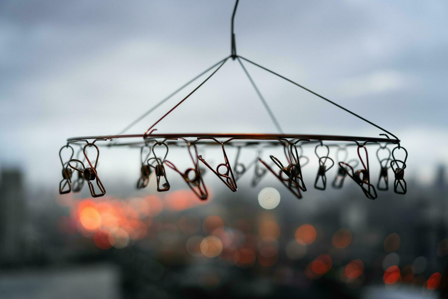 stänga upp av rostfri stål hängande klädnypor med suddig bakgrund av stad i regnig dag foto