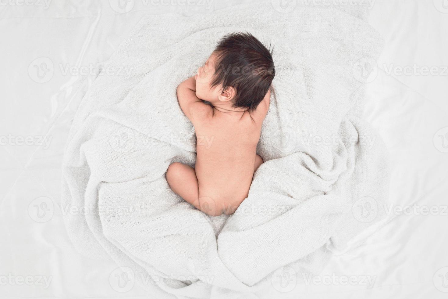 baby sover på mjuk vit filt, ovanifrån foto