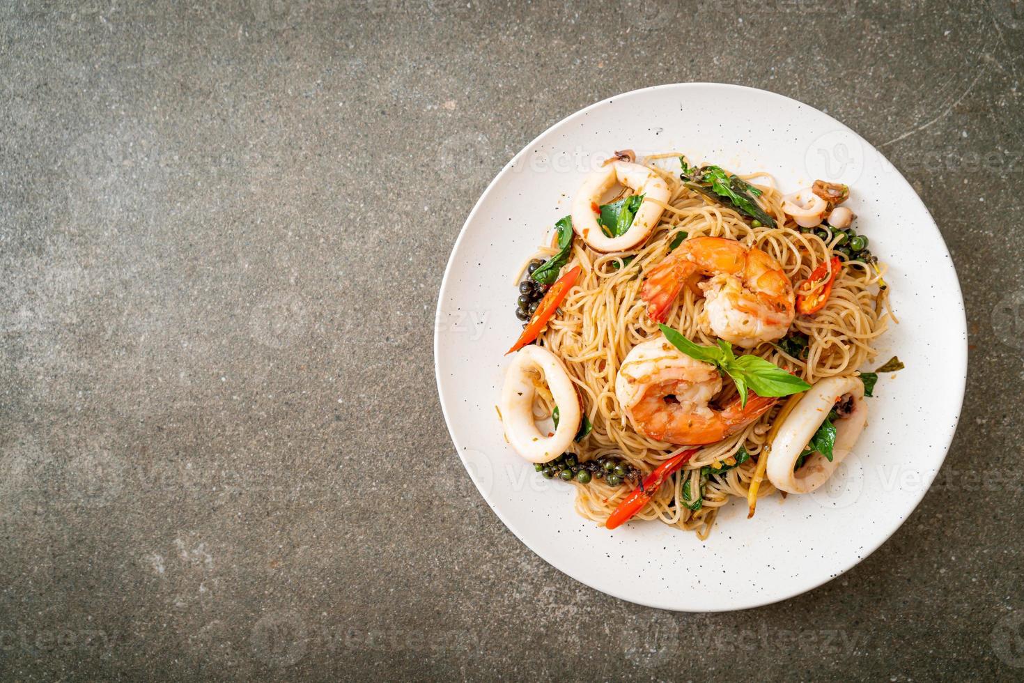 omrörda kinesiska nudlar med basilika, chili, räkor och bläckfisk - asiatisk matstil foto