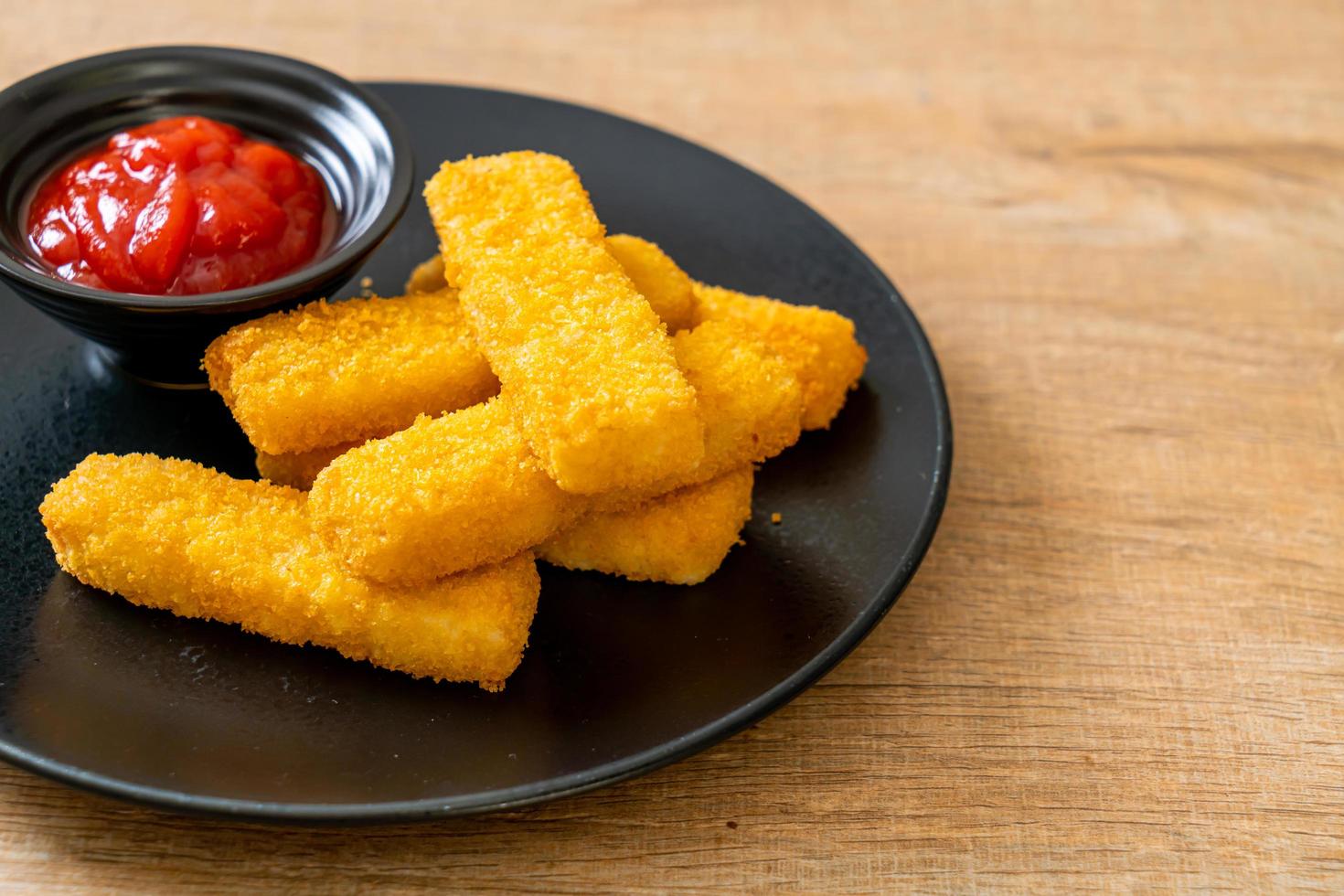 krispiga stekte fiskfingrar med brödsmulor serveras på tallrik med ketchup foto