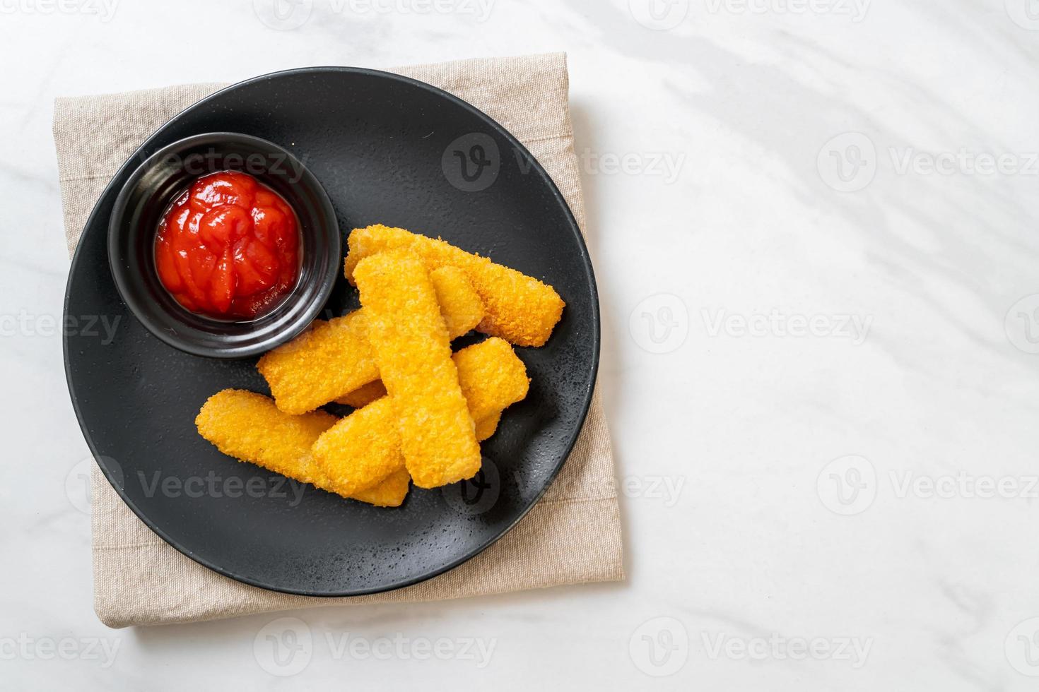 krispiga stekte fiskfingrar med brödsmulor serveras på tallrik med ketchup foto