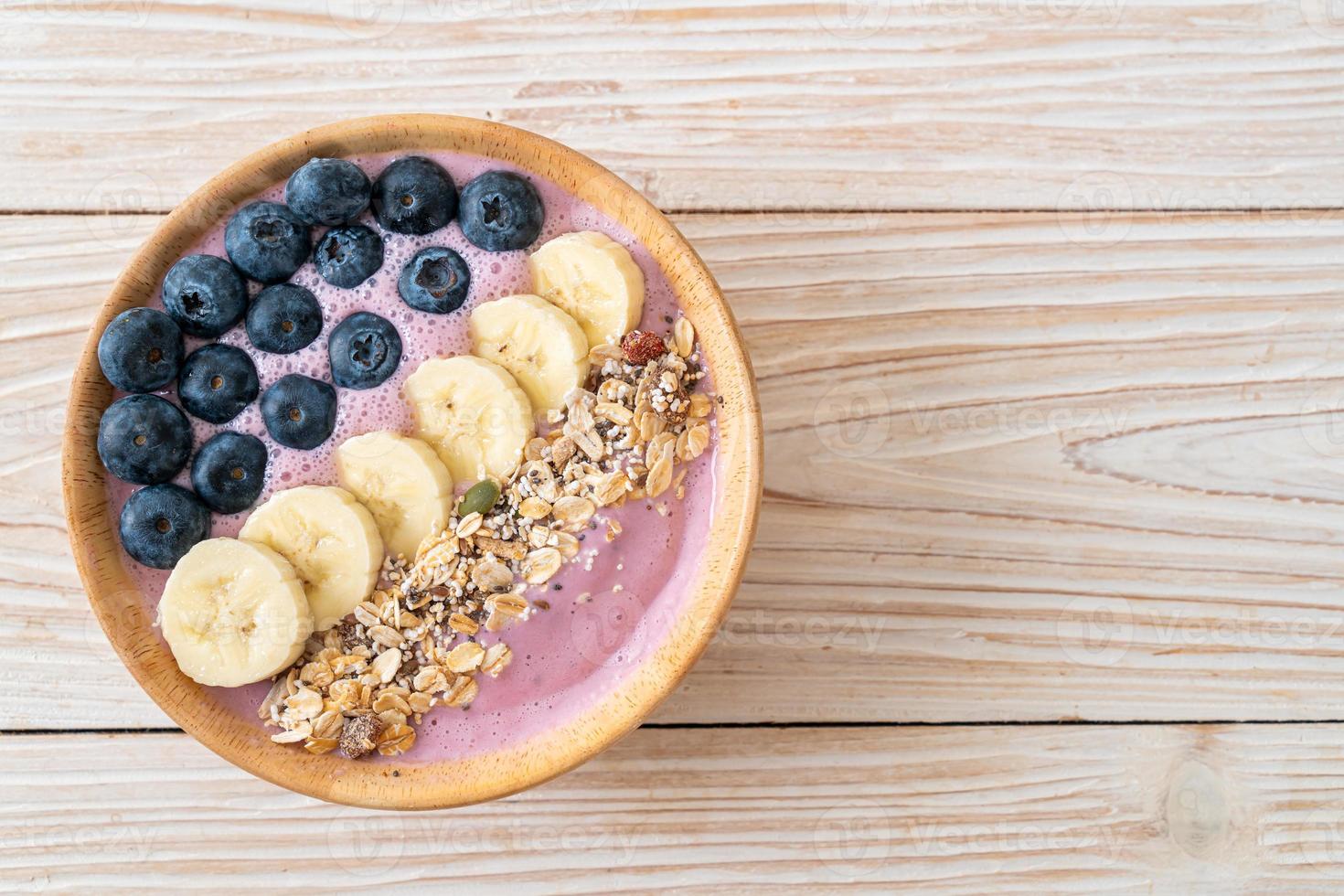 yoghurt eller smoothieskål med blåbär, banan och granola - hälsosam matstil foto