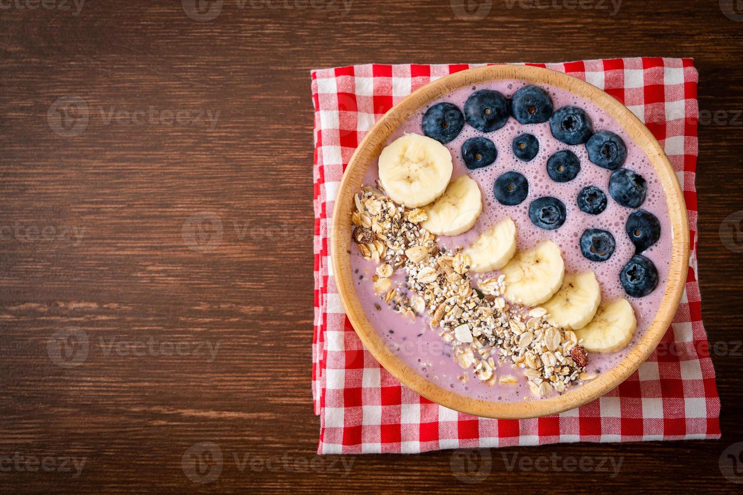 yoghurt eller smoothieskål med blåbär, banan och granola - hälsosam matstil foto