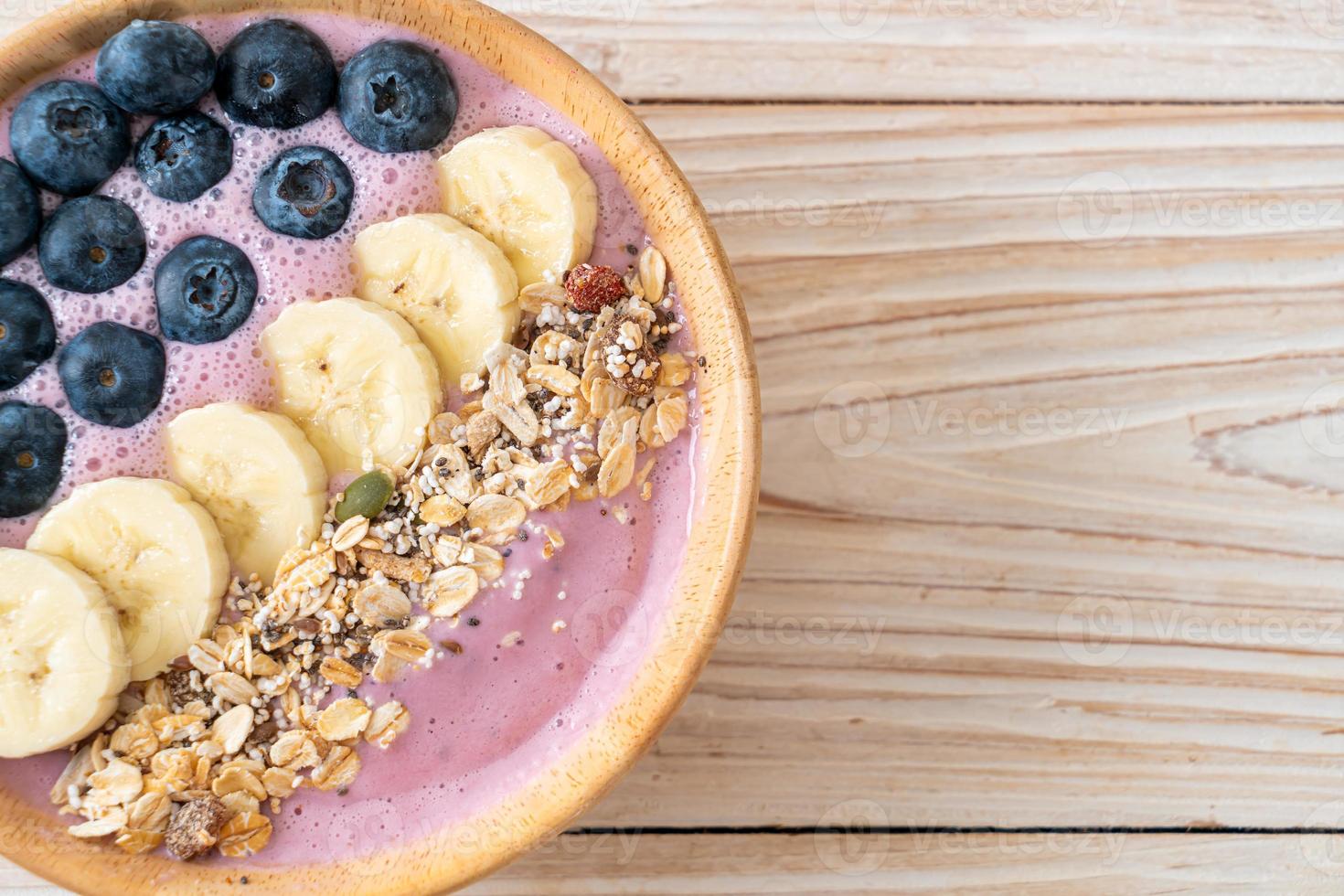 yoghurt eller smoothieskål med blåbär, banan och granola - hälsosam matstil foto