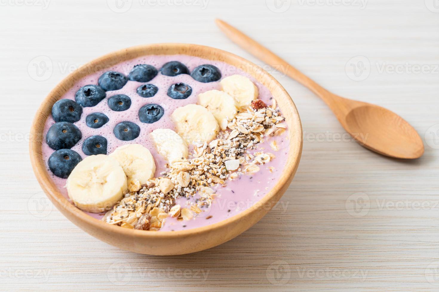 yoghurt eller smoothieskål med blåbär, banan och granola - hälsosam matstil foto