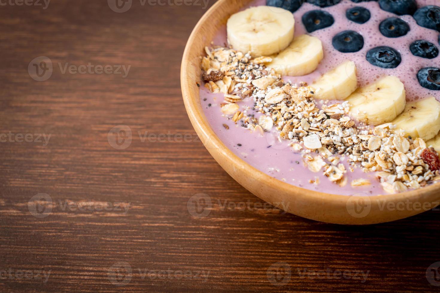 yoghurt eller smoothieskål med blåbär, banan och granola - hälsosam matstil foto