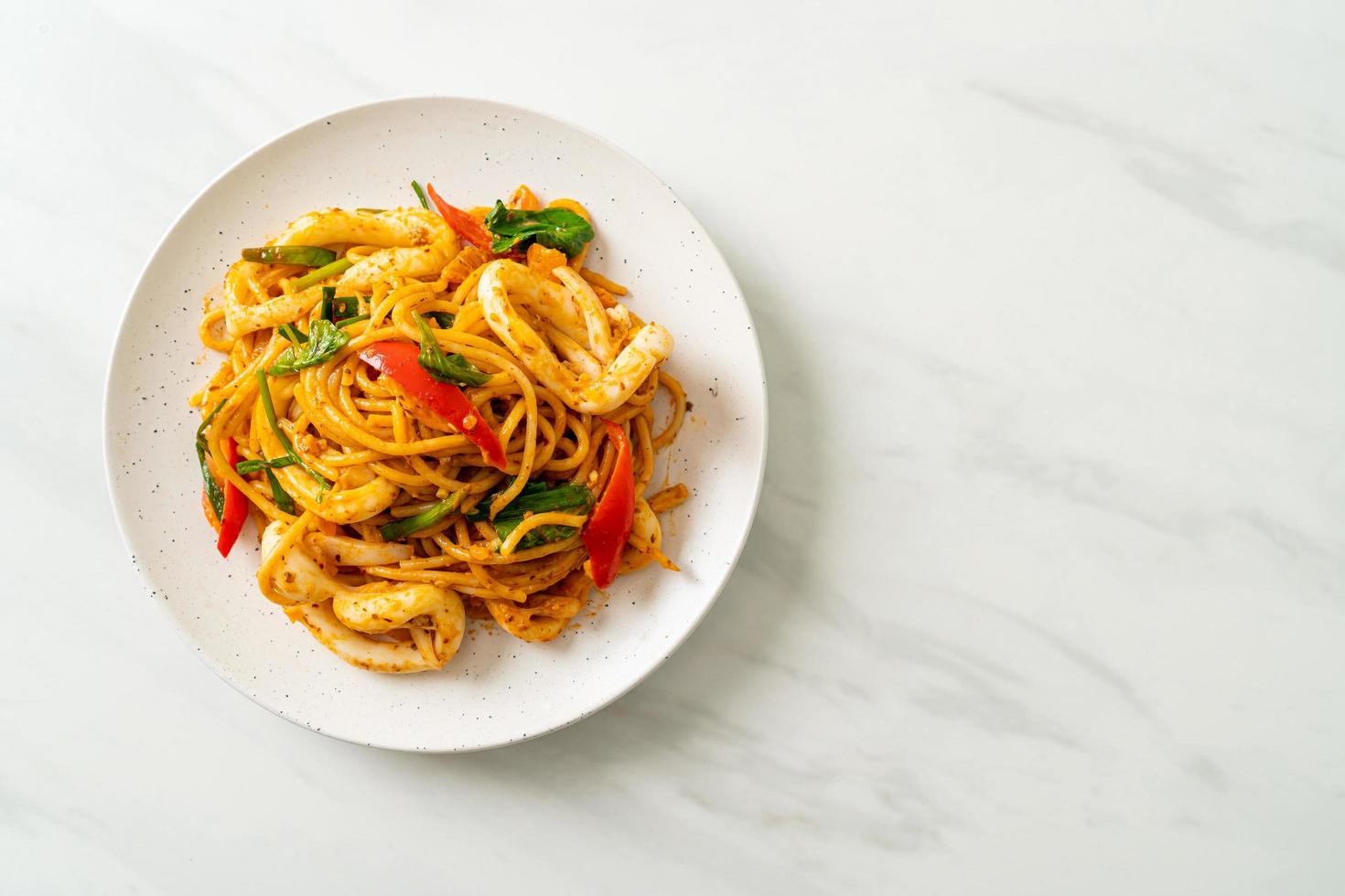 stekt spagetti med saltat ägg och bläckfisk - fusionsmatstil foto