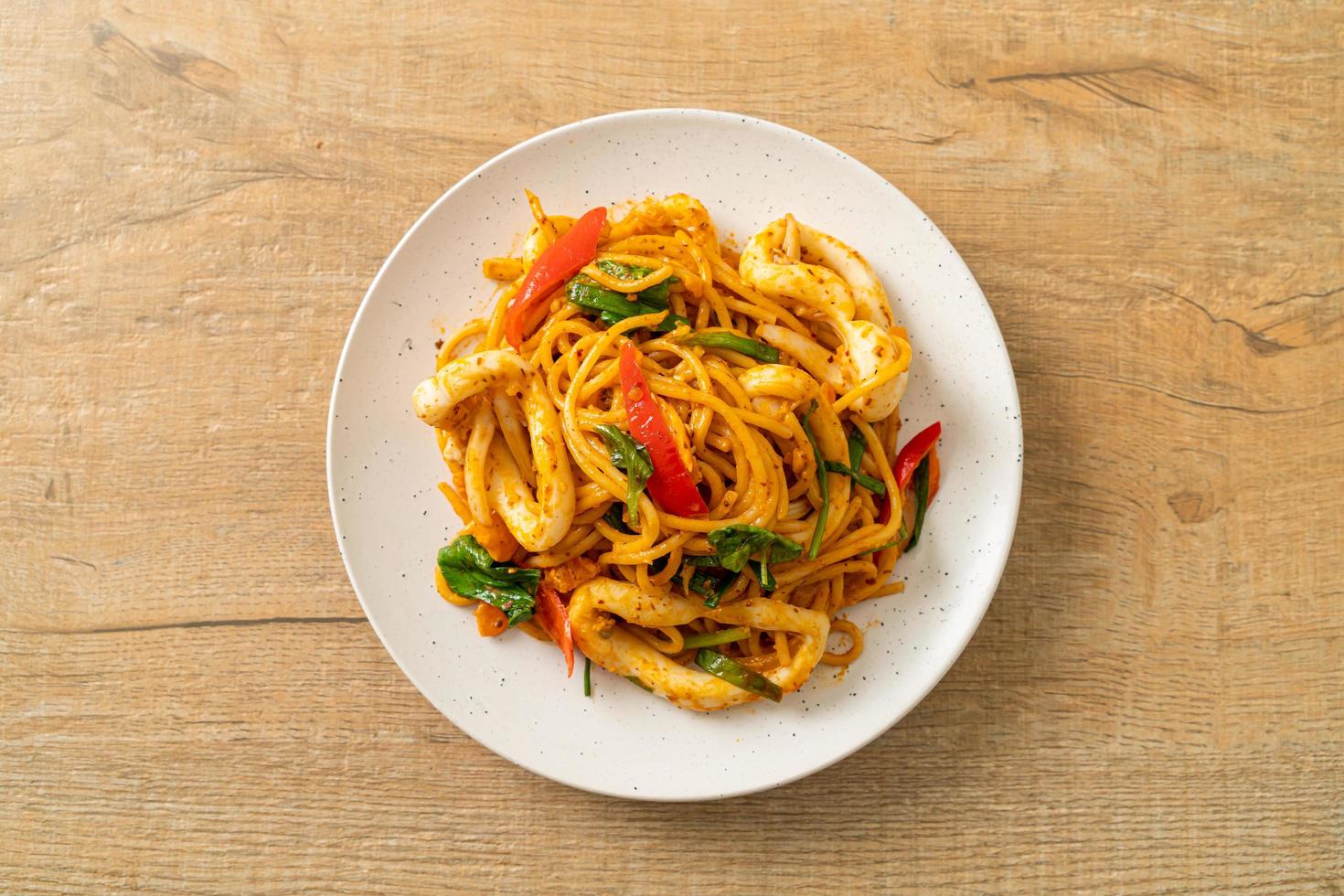 stekt spagetti med saltat ägg och bläckfisk - fusionsmatstil foto