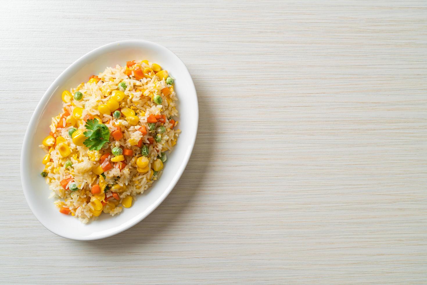 hemlagat stekt ris med blandade grönsaker av morot, gröna bönor, majs och ägg foto