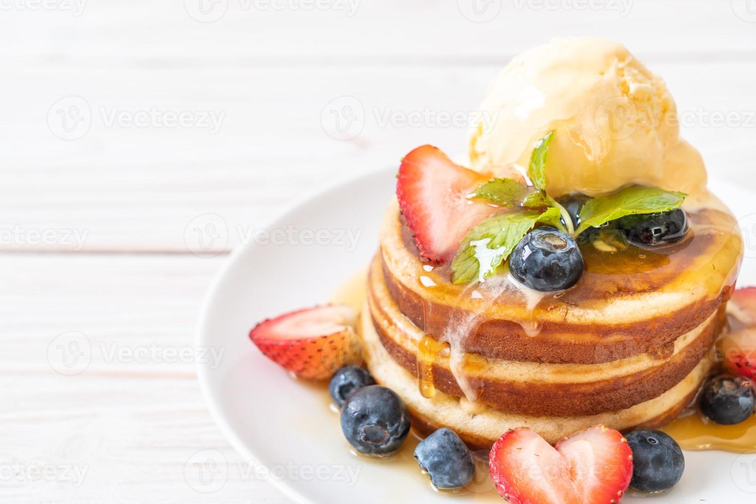 souffelpannkaka med blåbär, jordgubbar, honung och vaniljglass foto