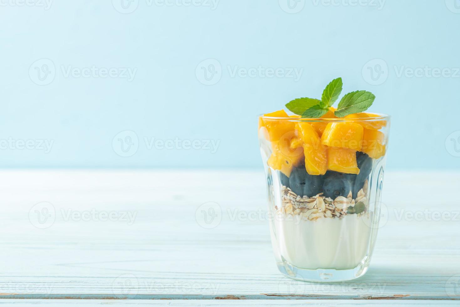 hemlagad färsk mango och färskt blåbär med yoghurt och granola - hälsosam matstil foto