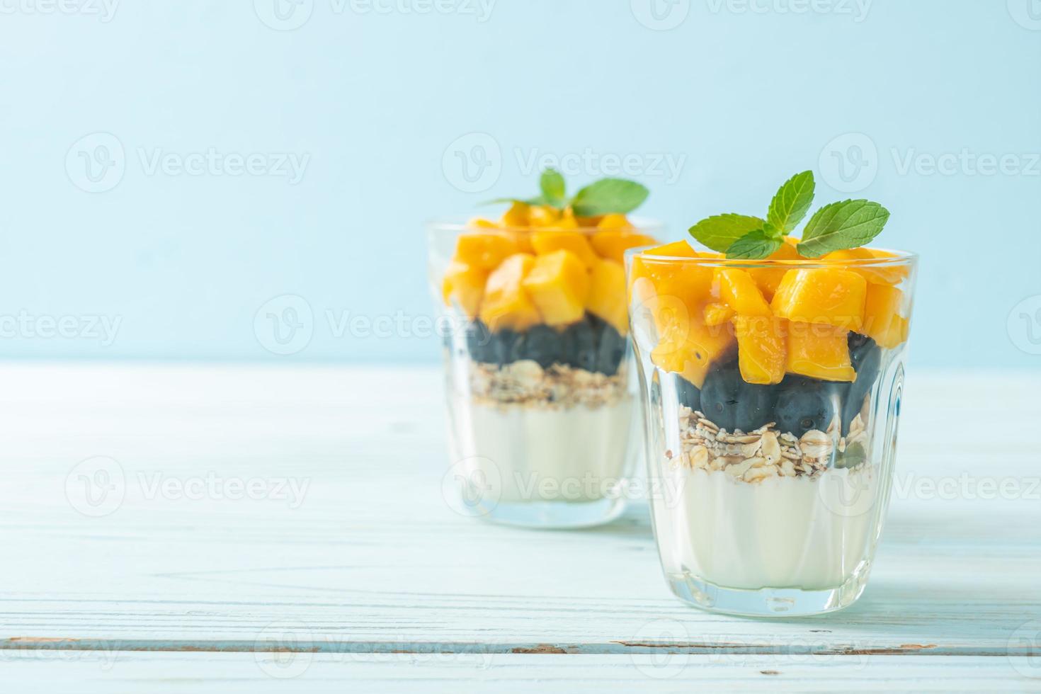 hemlagad färsk mango och färskt blåbär med yoghurt och granola - hälsosam matstil foto