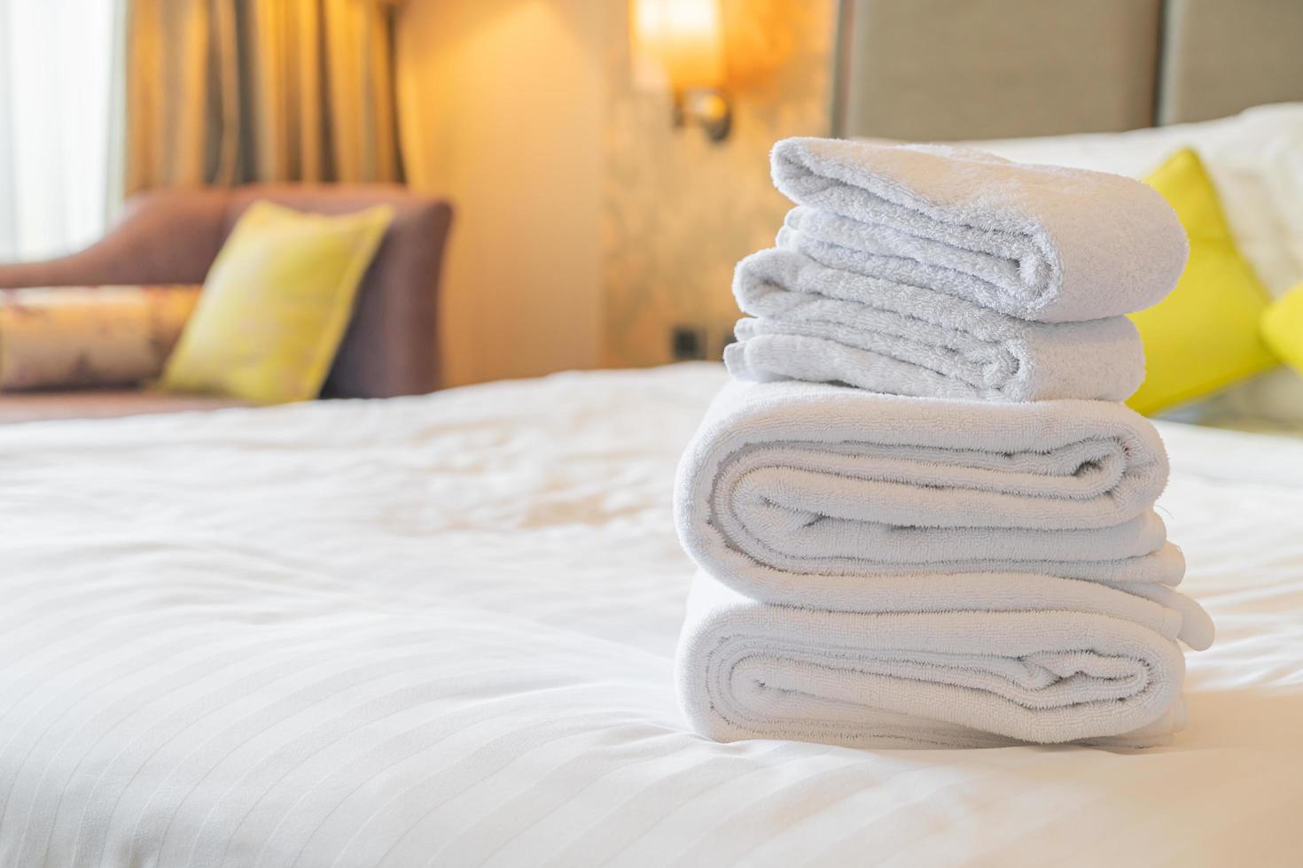 vit handduk vik på sängen i hotellort foto