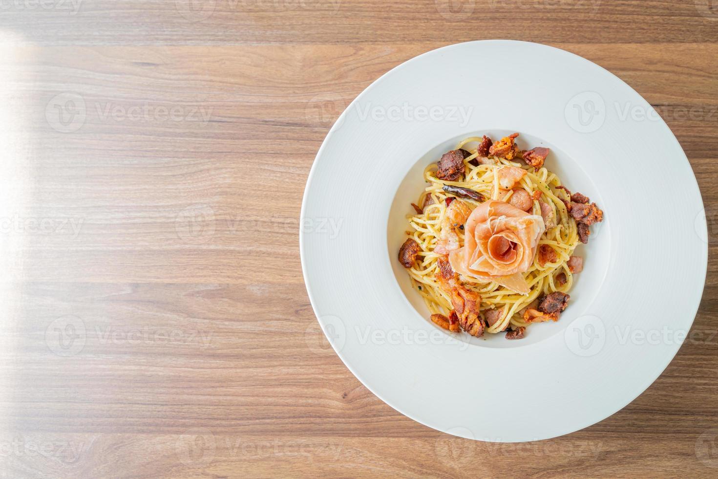 spagetti med chili, olivolja och prosciutto bacon - italiensk matstil foto