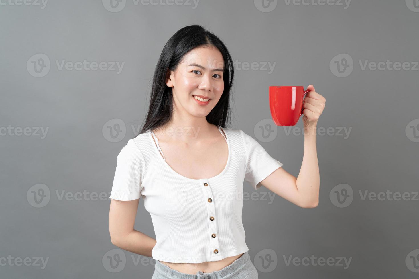 ung asiatisk kvinna med lyckligt ansikte och hand som håller kaffekoppen foto