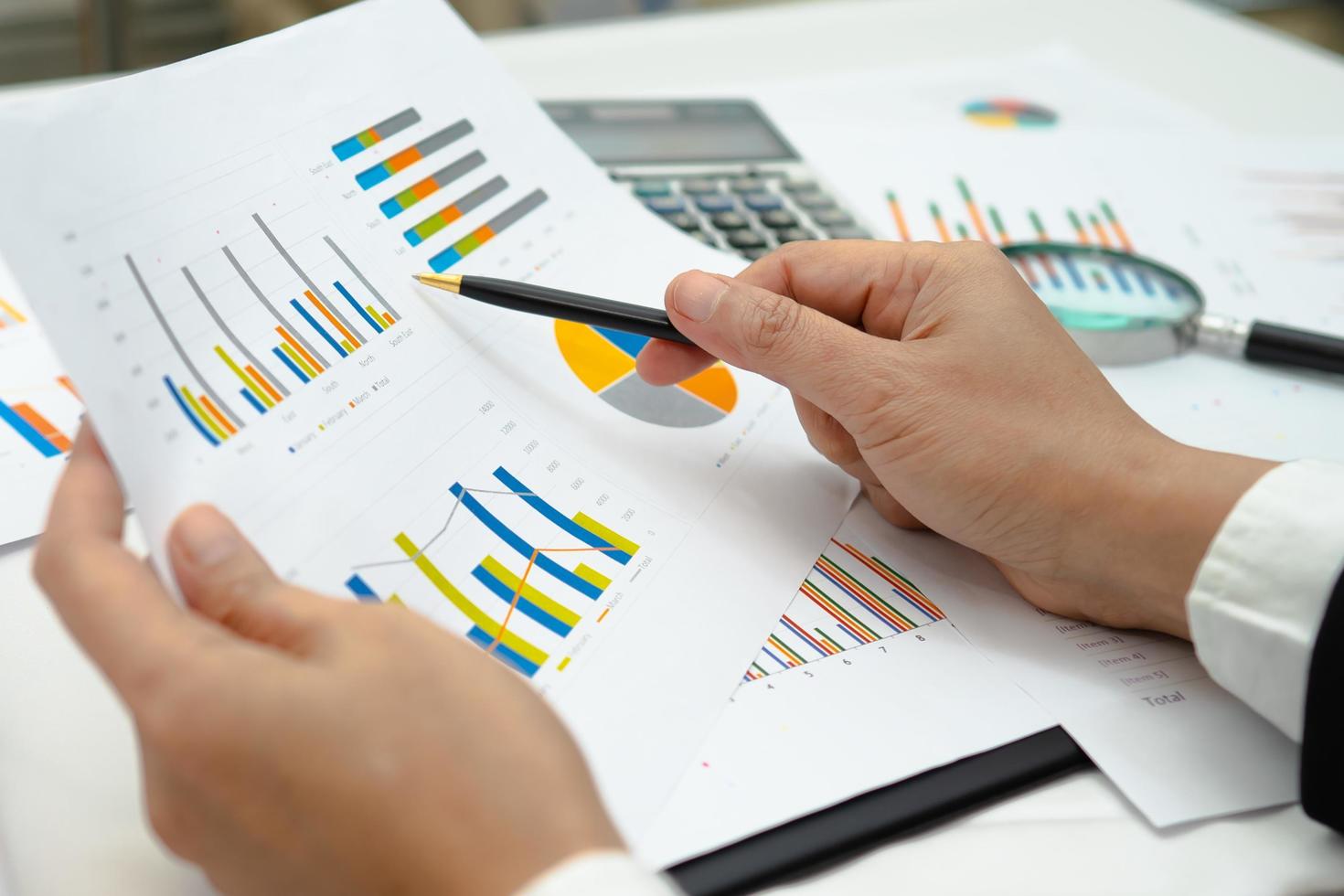 asiatisk revisor som arbetar och analyserar finansiella rapporter projektredovisning med diagramdiagram och kalkylator i modernt kontor, ekonomi och affärsidé. foto