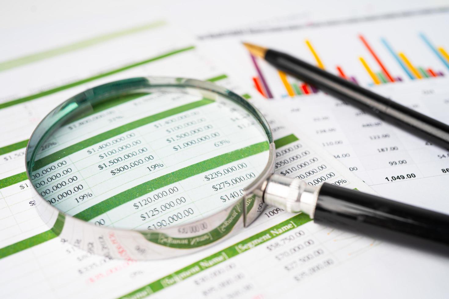 förstoringsglas på diagram diagrampapper. finansiell utveckling, bankkonto, statistik, investeringsanalys, forskningsdataekonomi, börshandel, affärskontorsföretagskoncept. foto