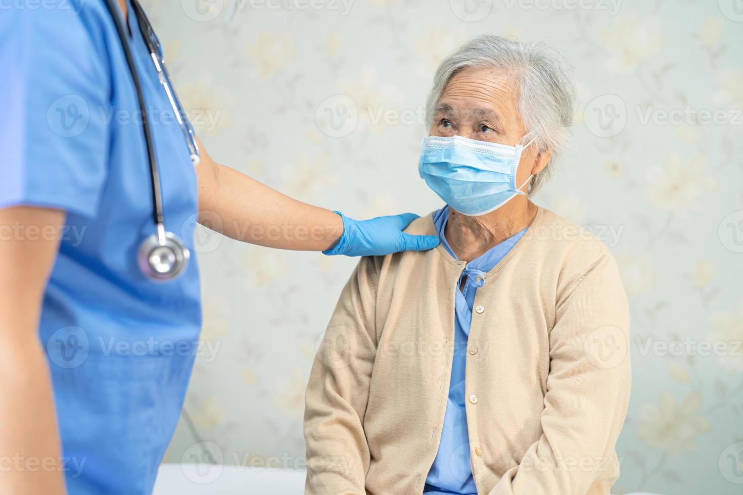 läkare som kontrollerar asiatisk senior eller äldre gammal damkvinnapatient som bär en ansiktsmask på sjukhus för att skydda infektion covid-19 coronavirus. foto