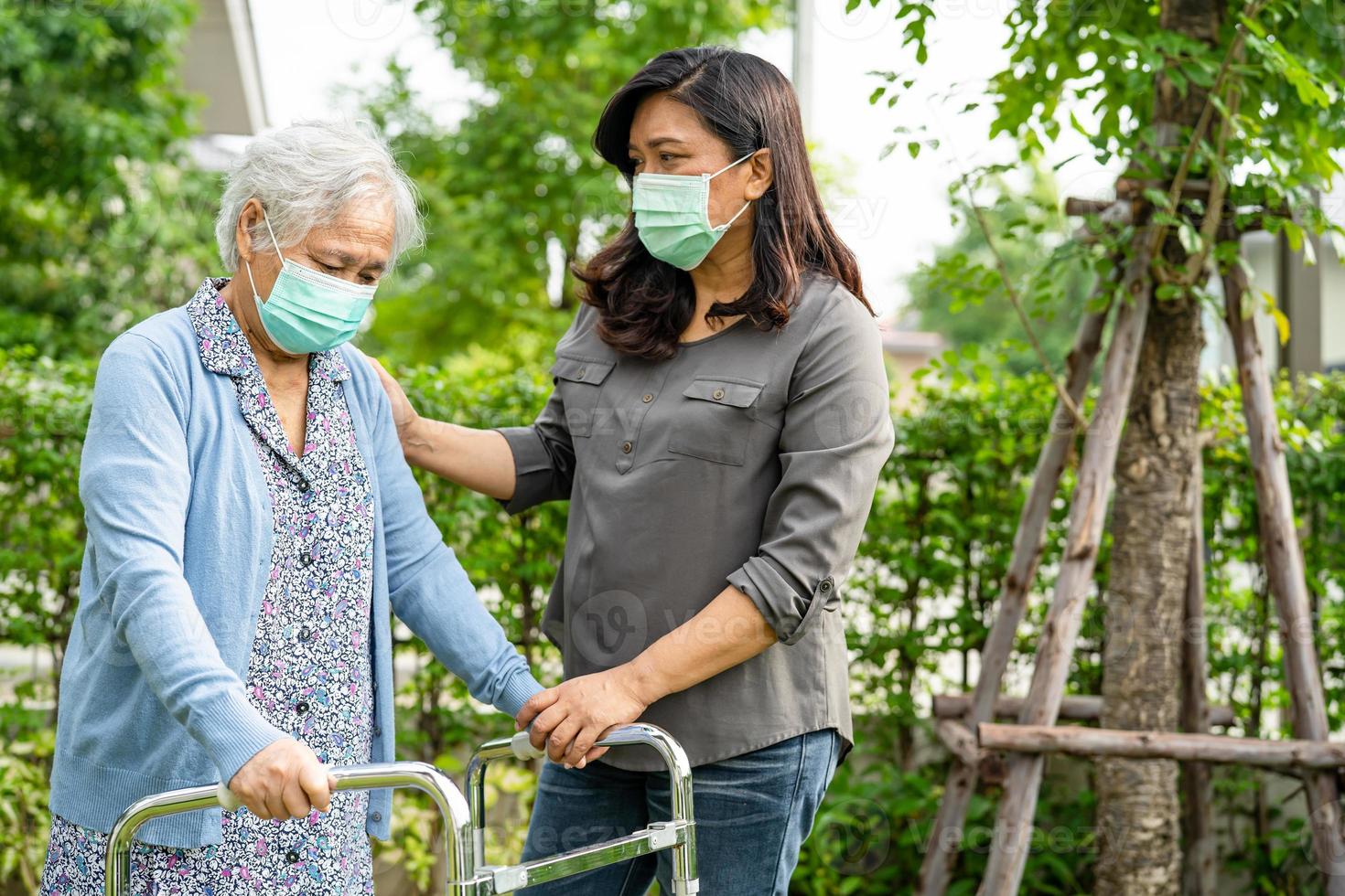 asiatisk senior eller äldre gammal damkvinna går med rullator och bär en ansiktsmask för att skydda säkerhetsinfektion och dödar nytt coronavirus covid-19-virus. foto