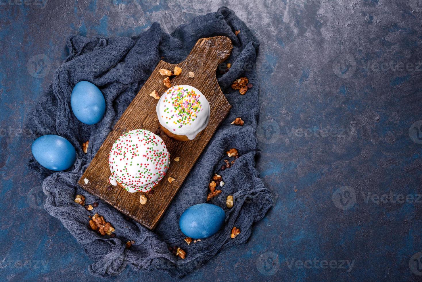 festkakor med vit glasyr, nötter och russin med påskägg på festbordet foto