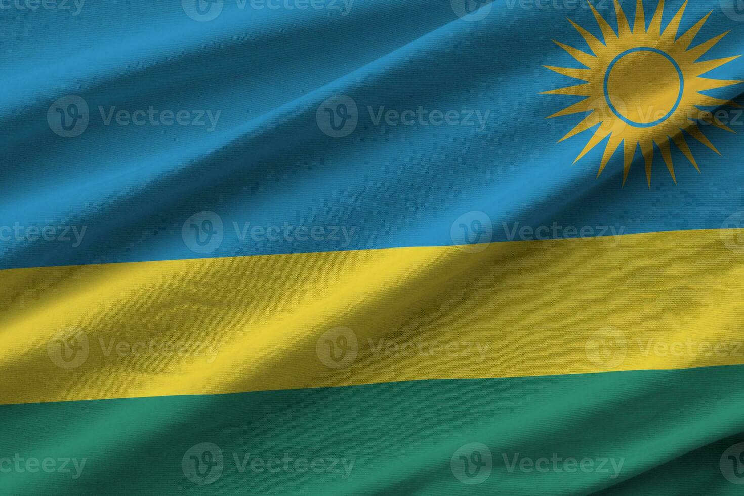 rwanda flagga med stor veck vinka stänga upp under de studio ljus inomhus. de officiell symboler och färger i baner foto