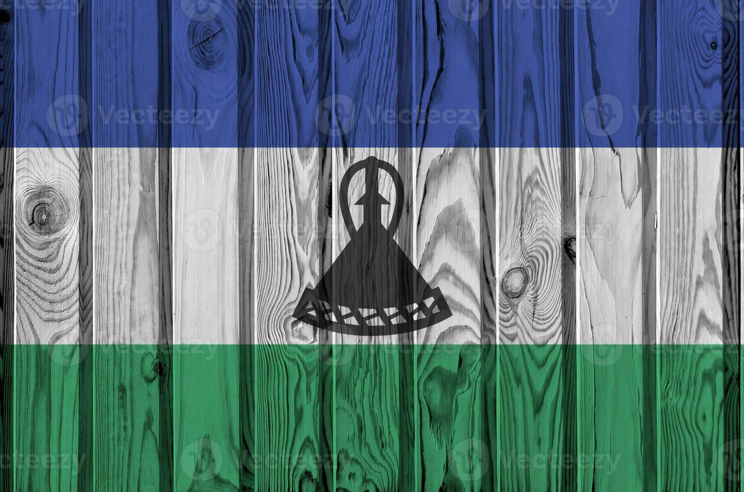 lesotho flagga avbildad i ljus måla färger på gammal trä- vägg. texturerad baner på grov bakgrund foto